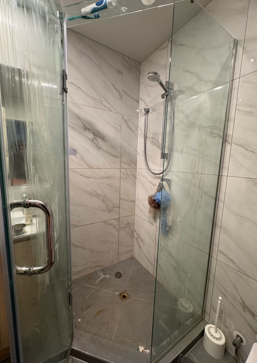 Shower glass and floor before an UrbanShine cleaning service in Auckland